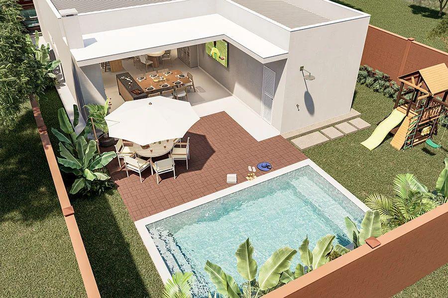 Vista aérea de uma casa decorada do empreendimento Casas Le Jardin, destacando a área de lazer privativa com piscina, deck, mesa de jardim sob guarda-sol e um playground em um quintal gramado.